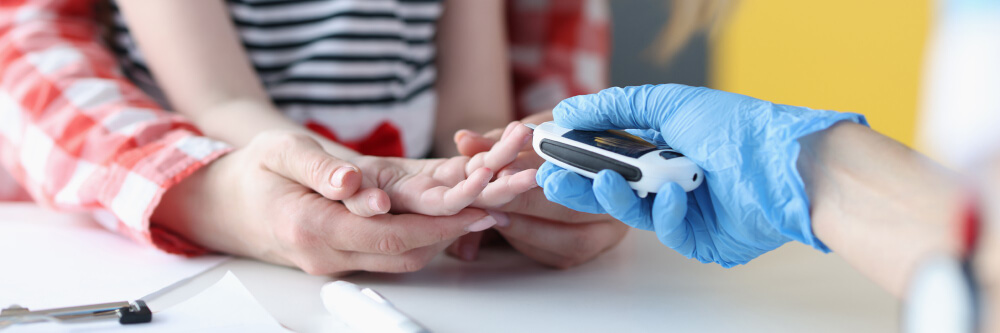 Glucometro Pediatrico Niña recibiendo asistencia pediátrica con un glucómetro