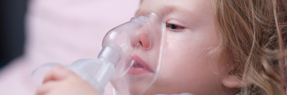 Nebulizador pediátrico Niña con nebulizador puesto